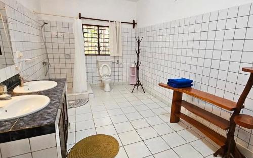 a bathroom with two sinks and a toilet at Beach House - private room in Diani Beach