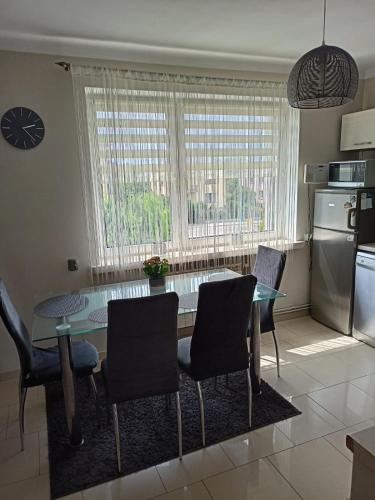 a kitchen with a glass table and chairs in a kitchen at Apartament Kalia in Zamość