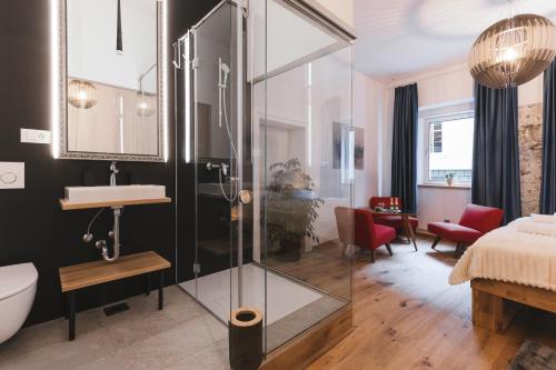 a bathroom with a glass shower and a sink at Sobe Lotrist in Radovljica