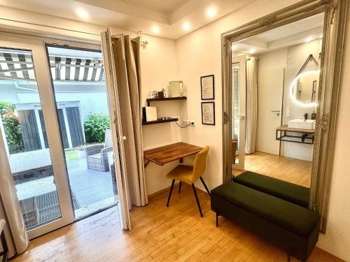 a room with a mirror and a table and a chair at VILLA ORCHARD Frankfurt - Trade Fair Airport in Kriftel
