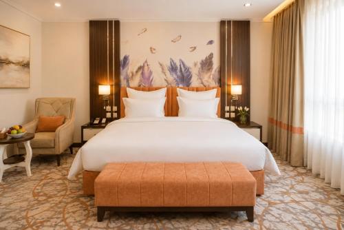 a hotel room with a large bed and a chair at TULIP PLAZA - By Le Park Concord in Hafr Al-Batin