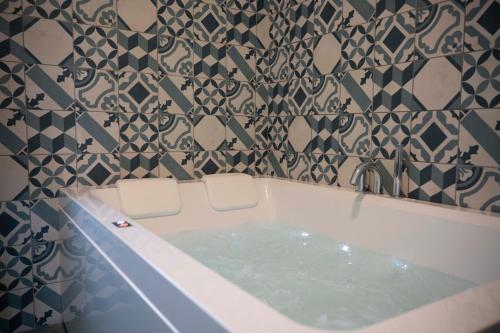 a bathroom with a bath tub with two white chairs at Relais Terramare in Cellole