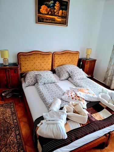 a bed with blankets and pillows on it in a room at Csodarét Kúria in Mórahalom