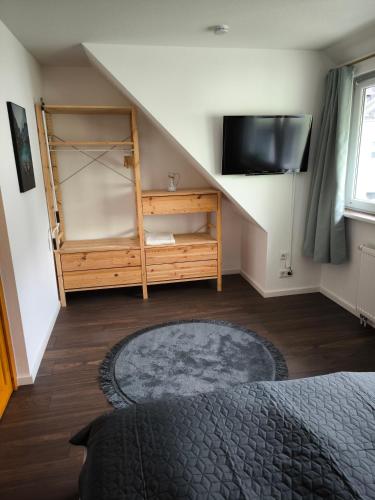 a room with a staircase with a tv and a bed at Ferienwohnung Weyer in Villmar