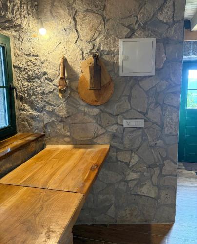 a wooden counter against a stone wall with a hat on it at Košara Trišnjevac in Lusnić