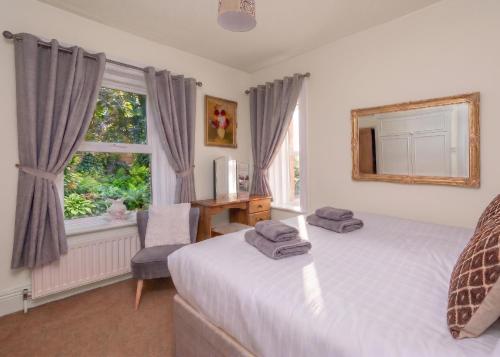 a bedroom with two beds and a window at Big Pink House in Mealsgate