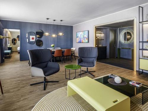 ein Wohnzimmer mit Stühlen und einem Tisch in der Unterkunft Pullman Santiago El Bosque in Santiago