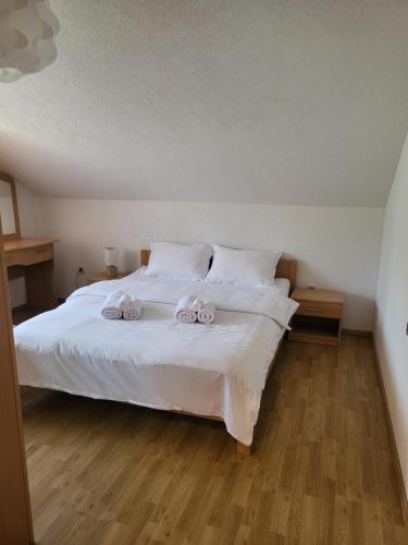 a bedroom with a white bed with two towels on it at Duvnjak Rooms & House in Livno