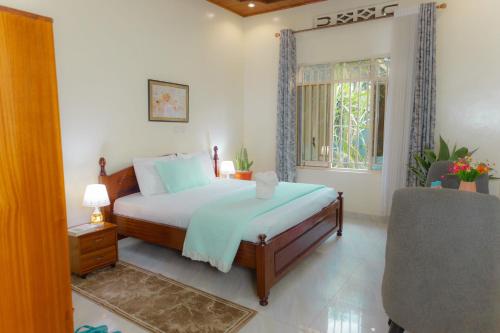 a bedroom with a bed and a chair and a window at Volcano Visita in Cyuve