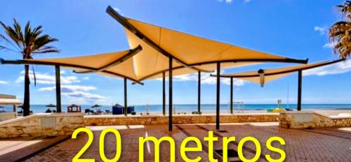 a group of umbrellas on a beach with the words metro at Los BOLICHES Playa in Fuengirola
