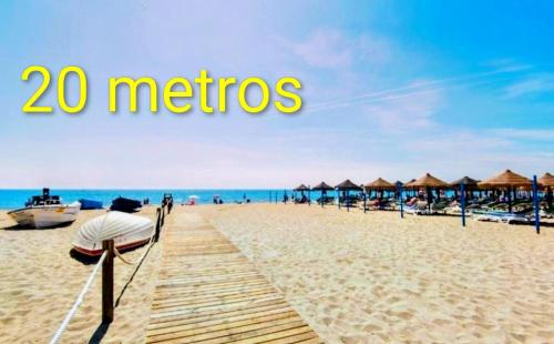 a person standing on a beach with a pier at Los BOLICHES Playa in Fuengirola