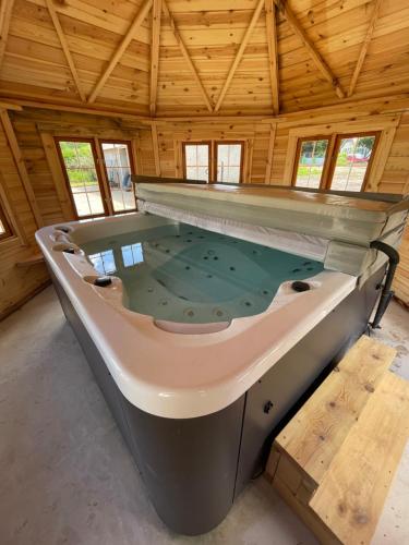 a large bath tub in a room with a wooden ceiling at Le clos du Breuchin in Breuchotte