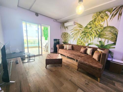 a living room with a couch and a plant on the wall at s2 fontaine in Nabeul