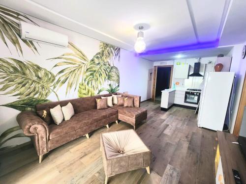 a living room with a couch and a palm mural at s2 fontaine in Nabeul