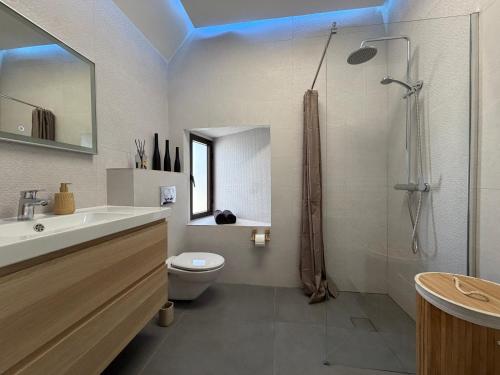 a bathroom with a shower and a sink and a toilet at Sunset Paradise in Baie Nettle