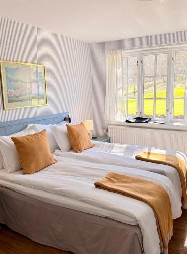 a large white bed in a room with windows at Kullagård Hotell in Mölle