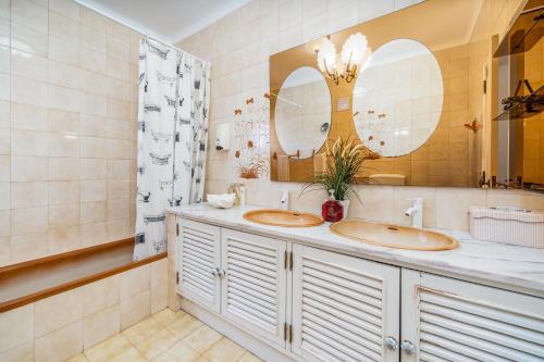 a bathroom with two sinks and two mirrors at Don Sidónio Alojamentos in Portimão