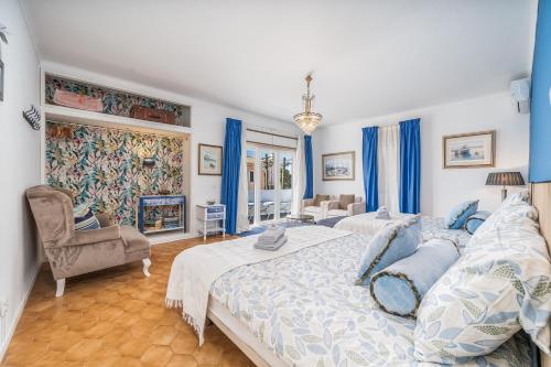 a large bedroom with two beds and a chair at Don Sidónio Alojamentos in Portimão