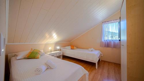 a attic room with two beds and a window at Apartman Mario with pool by Villas Guide in Blato