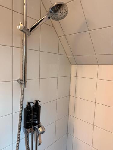 a shower with a shower head in a bathroom at Kullagård Hotell in Mölle