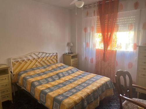 a bedroom with a bed and a dresser and a window at Piso Alicante in Alicante