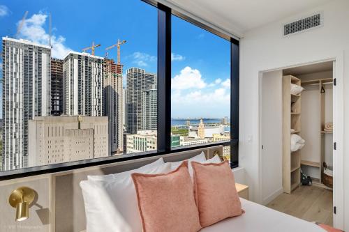 a bedroom with a large window with a view of the city at District 225 Condo by Ionica in Miami