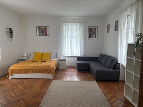 a living room with a bed and a couch at Tornácos Vendégház in Szécsény