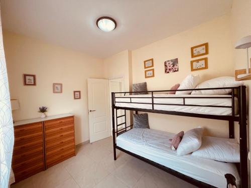 two bunk beds in a room with a dresser at Villa CARMENÇÓ in Empuriabrava