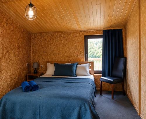a bedroom with a bed and a chair and a window at Ushguli Terrace in Ushguli