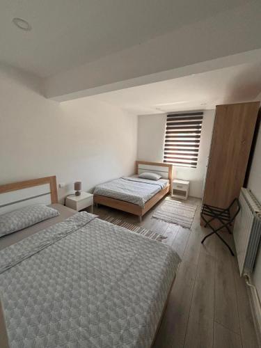 a bedroom with two beds and a window at Apartman Abramović in Topusko