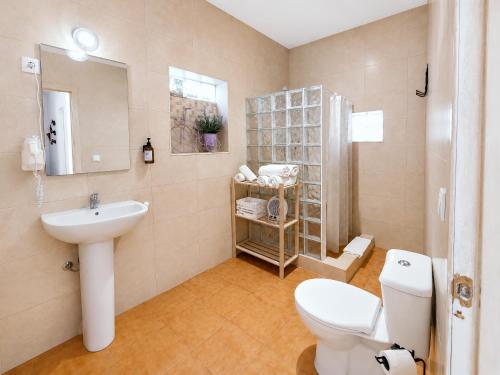 a bathroom with a white toilet and a sink at Quinta da Ponte das Hortas 3 in Elvas