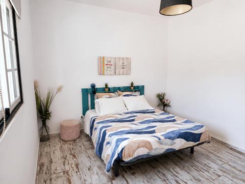 a bedroom with a bed with a blue and white comforter at Quinta da Ponte das Hortas 3 in Elvas
