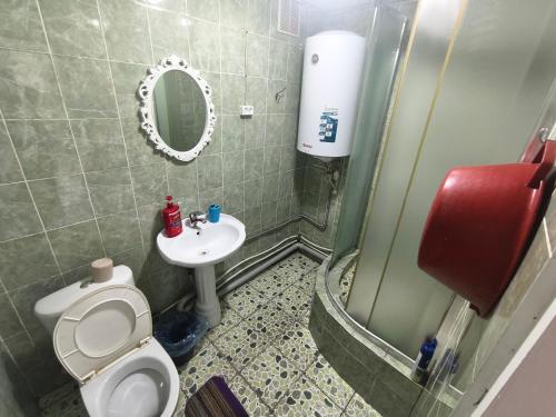 a bathroom with a toilet and a sink and a mirror at Rassvet in Lenīnogorsk