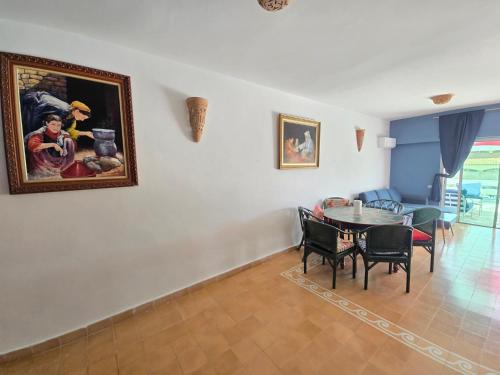 a living room with a table and a painting on the wall at lagoon apartment 2 in Moulay Bousselham