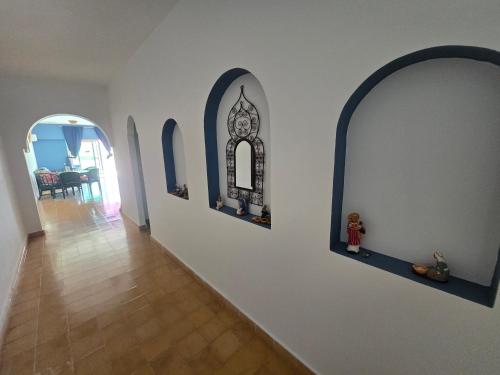 a hallway with arches and a clock on a wall at lagoon apartment 2 in Moulay Bousselham