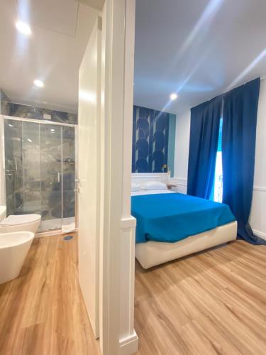 a bedroom with blue curtains and a bed and a tub at Hotel Europeo Napoli in Naples