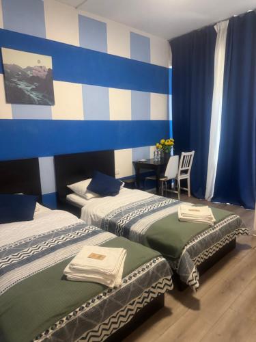 two beds in a room with blue and white stripes at Firenze inn 21 Florence in Florence