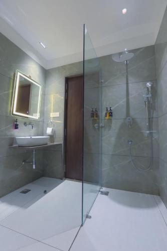 a bathroom with a shower and a sink at Hotel Nova Platinum Ujjain in Makoria Ām