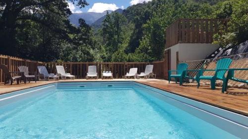 a swimming pool with chairs and a bunch ofituresitures at Camping 2 étoiles - Piscine - ccbfida in Vernet-les-Bains