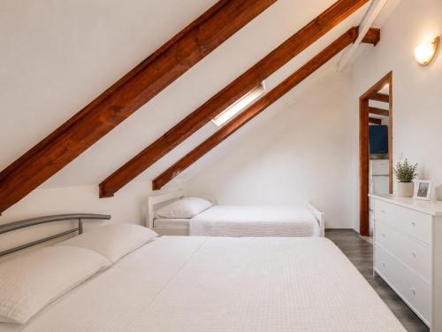 two beds in a attic bedroom with white walls and wooden beams at Quiet Oasis in the Heart of Old Town- two kitchen,3bath in Split