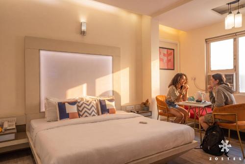 two women sitting at a table in a hotel room at Zostel Delhi in New Delhi