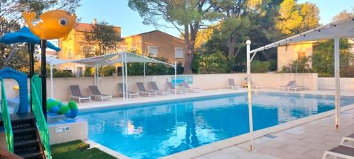 a large swimming pool with chairs and a playground at Camping 3 étoiles - Piscine - ccbfii0 in Châteauneuf-de-Gadagne