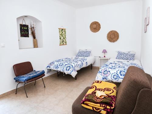 a room with two beds and a couch and a chair at Quinta da Ponte das Hortas 2 in Elvas