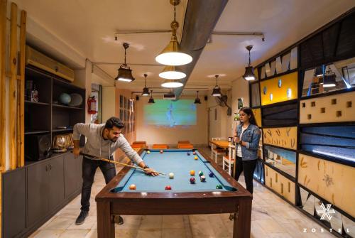 a man and a woman playing pool in a room at Zostel Delhi in New Delhi