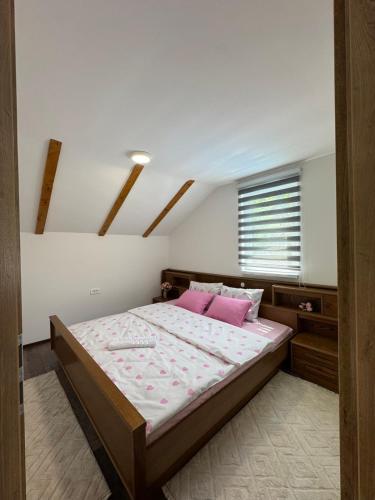 a bedroom with a large bed with pink pillows at Pool House in Toplica