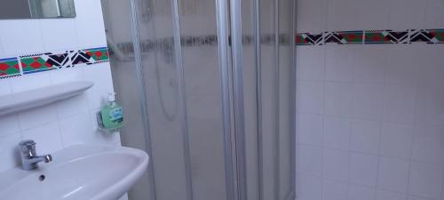 a white bathroom with a shower and a sink at Gemütliches Doppelzimmer mit Balkon in Furth im Wald