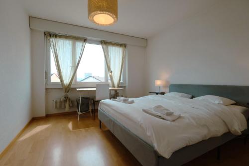 a bedroom with a large bed and a window at Cozy Apartment with Easy Access to Bern in Bern