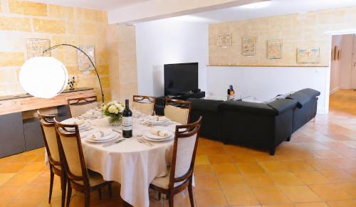 a living room with a table and a couch at Grande maison en pierre à Pomerol - 3 chambres, parking, proche Saint-Emilion in Pomerol
