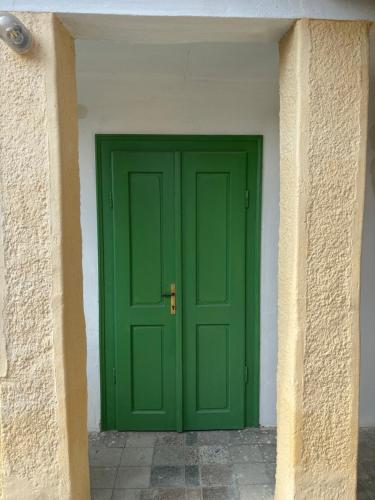 a green door in the corner of a building at Sárga-part Vendégház in Cserépváralja