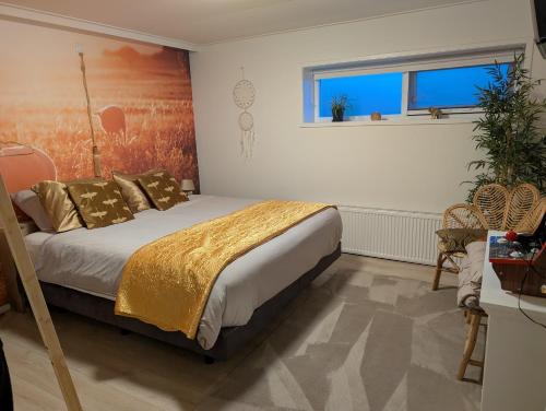 a bedroom with a bed with gold sheets and a window at Een Nije Dei in Arum